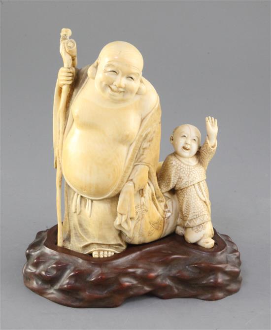 A Japanese ivory okimono of Hotei and a boy, early 20th century, height 16.5cm, wood stand